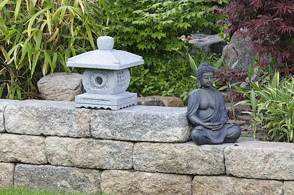 472356 - Wall with stone lantern and sitting Buddha