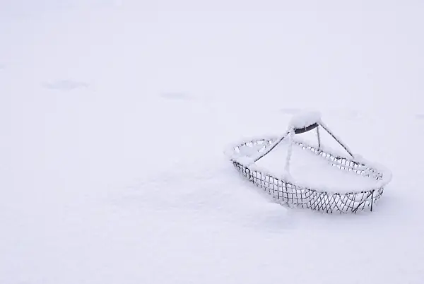517016 - Wire basket with wooden grip on the handle in deep snow