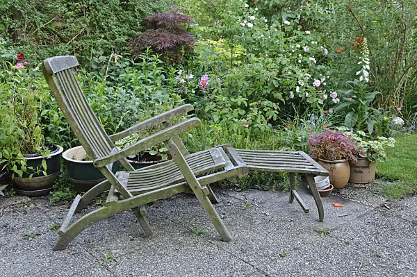 472371 - Wooden deck chair with potted plants
