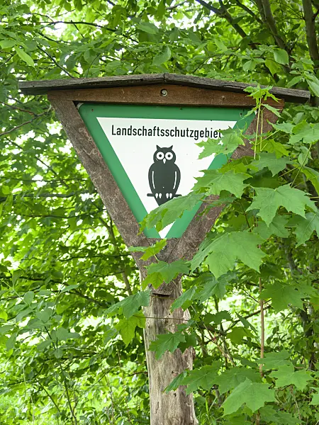 523247 - Wooden posts with signpost "Landschaftsschutzgebiet" and owl
